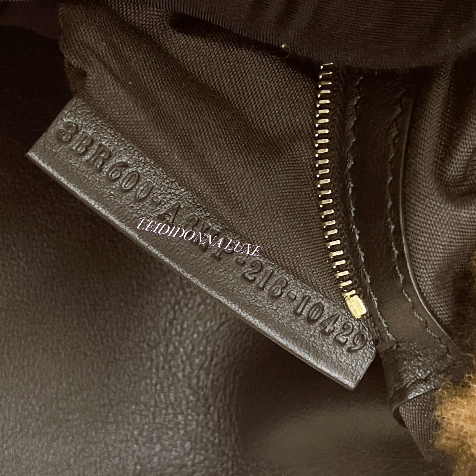 Close-up of a textured surface with a label and zipper detail.