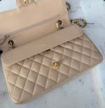Load image into Gallery viewer, Beige quilted handbag with gold accents on a marble surface

