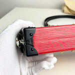 将图片加载到图库查看器，Red guitar case with black latches held by a gloved hand on a light background
