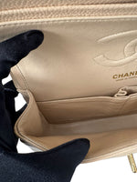 Load image into Gallery viewer, Beige Chanel handbag held by a gloved hand on a white background
