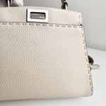 将图片加载到图库查看器，Close-up of a beige handbag with a silver clasp on a light background
