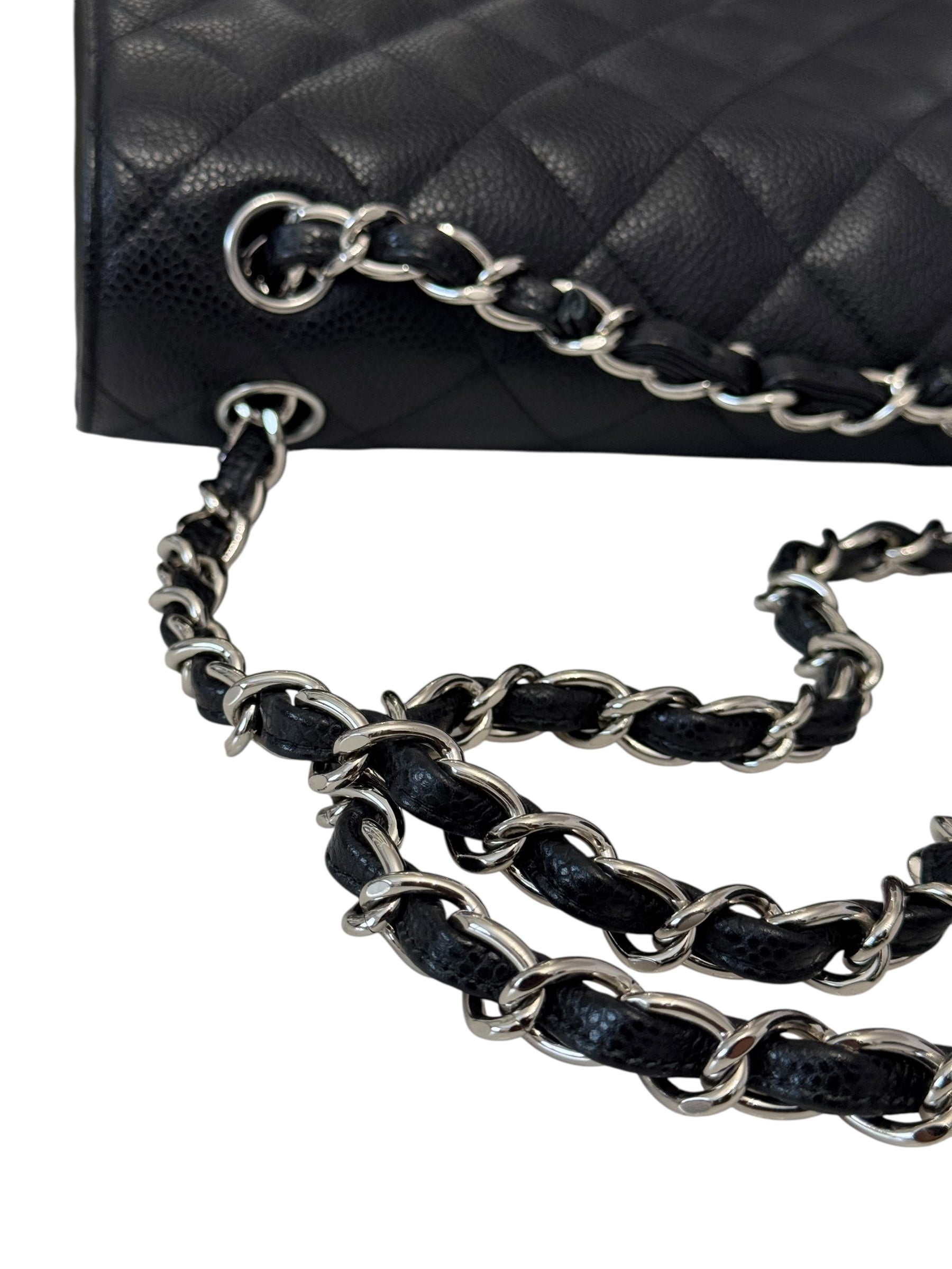 Black quilted handbag with a silver chain strap on a white background