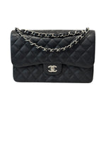 将图片加载到图库查看器，Black quilted handbag with silver chain on a white background
