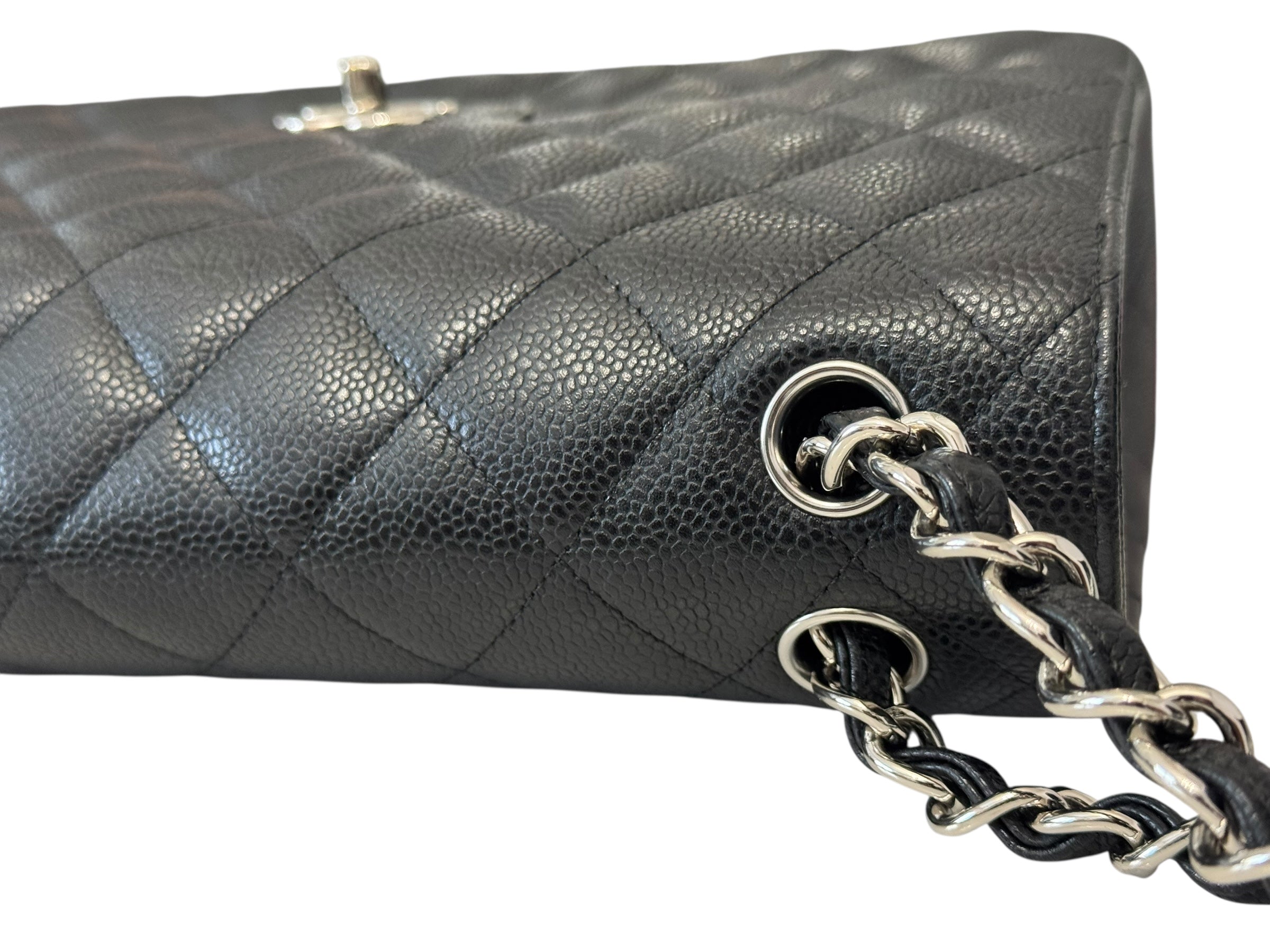 Black quilted handbag with silver chain strap on a white background