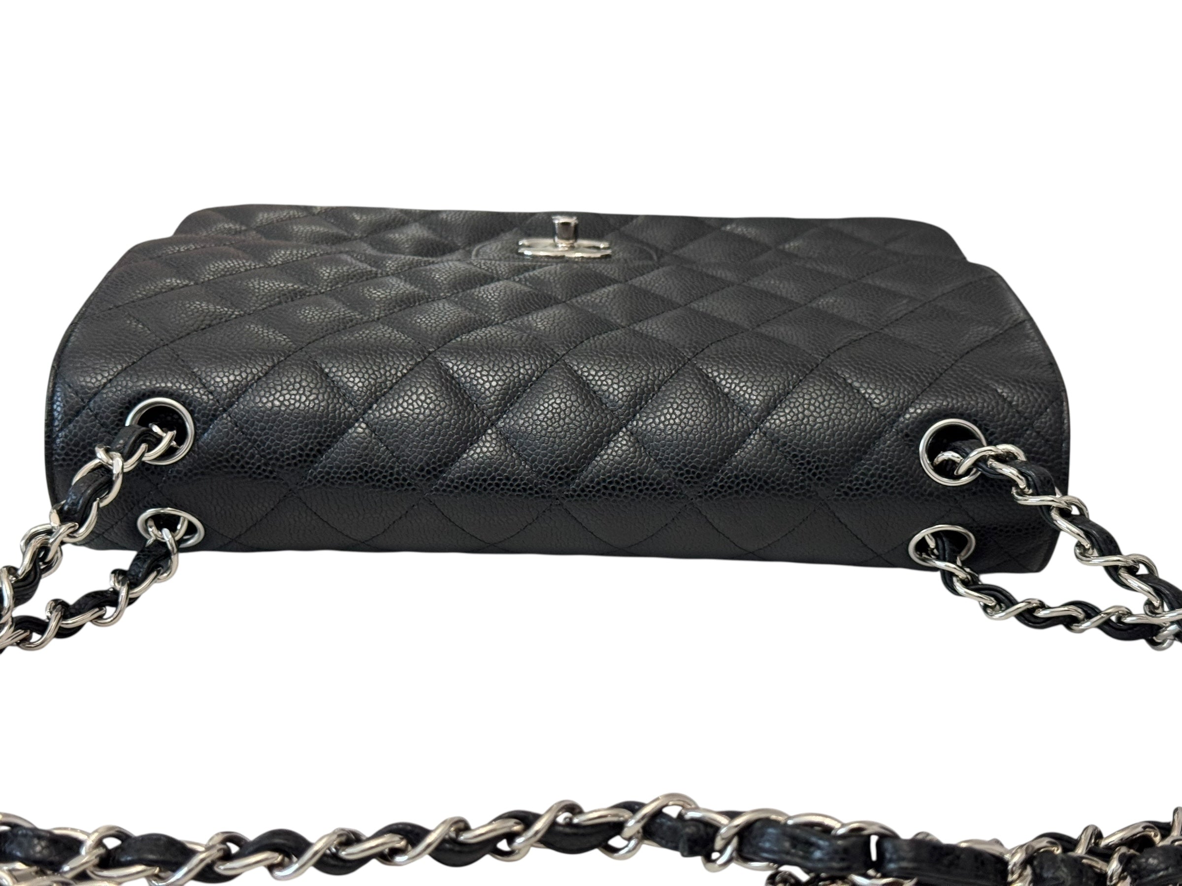 Black quilted handbag with silver chain strap on a white background