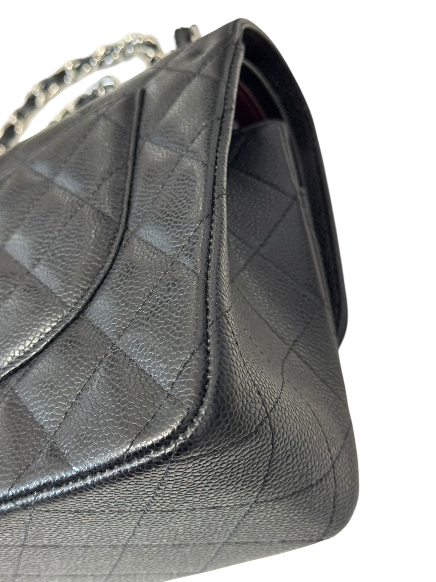Black quilted handbag on a white background