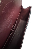 将图片加载到图库查看器，Close-up of a Chanel handbag with visible branding on a white background
