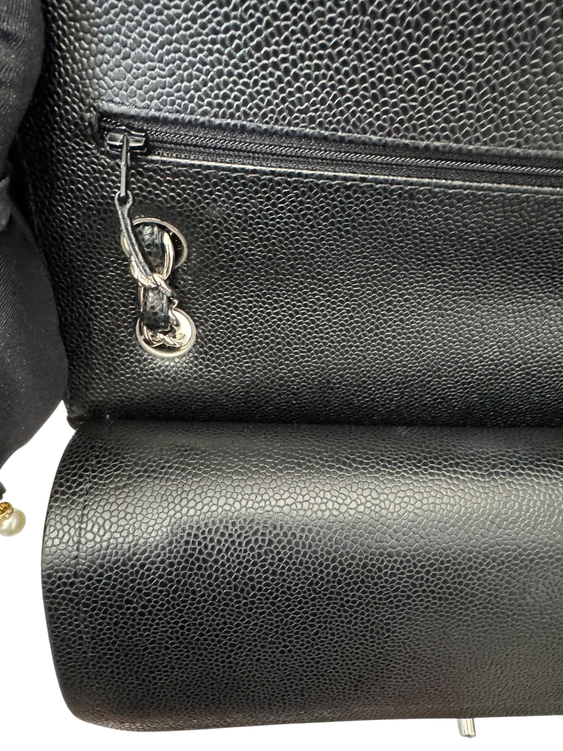 Close-up of a black leather bag with a zipper