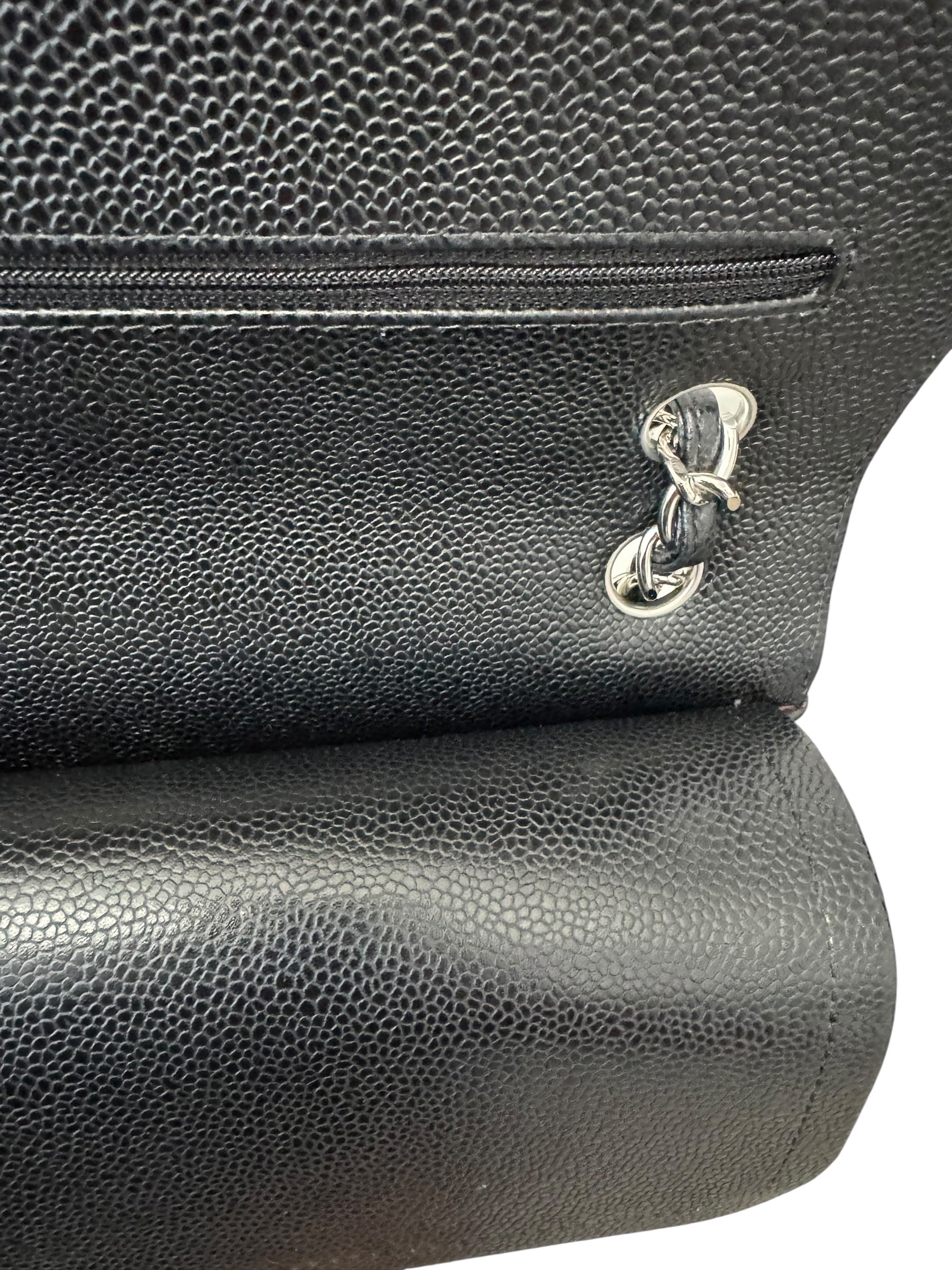 Close-up of a black leather bag with a gold clasp on a white background