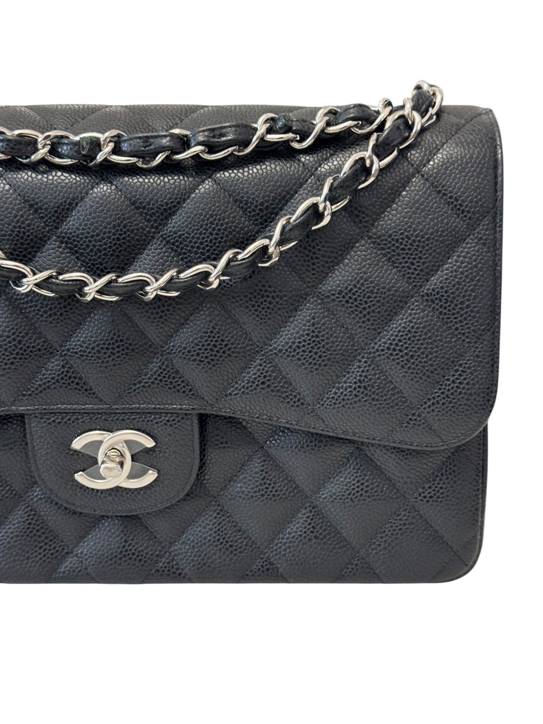 Black quilted handbag with silver chain strap on a white background