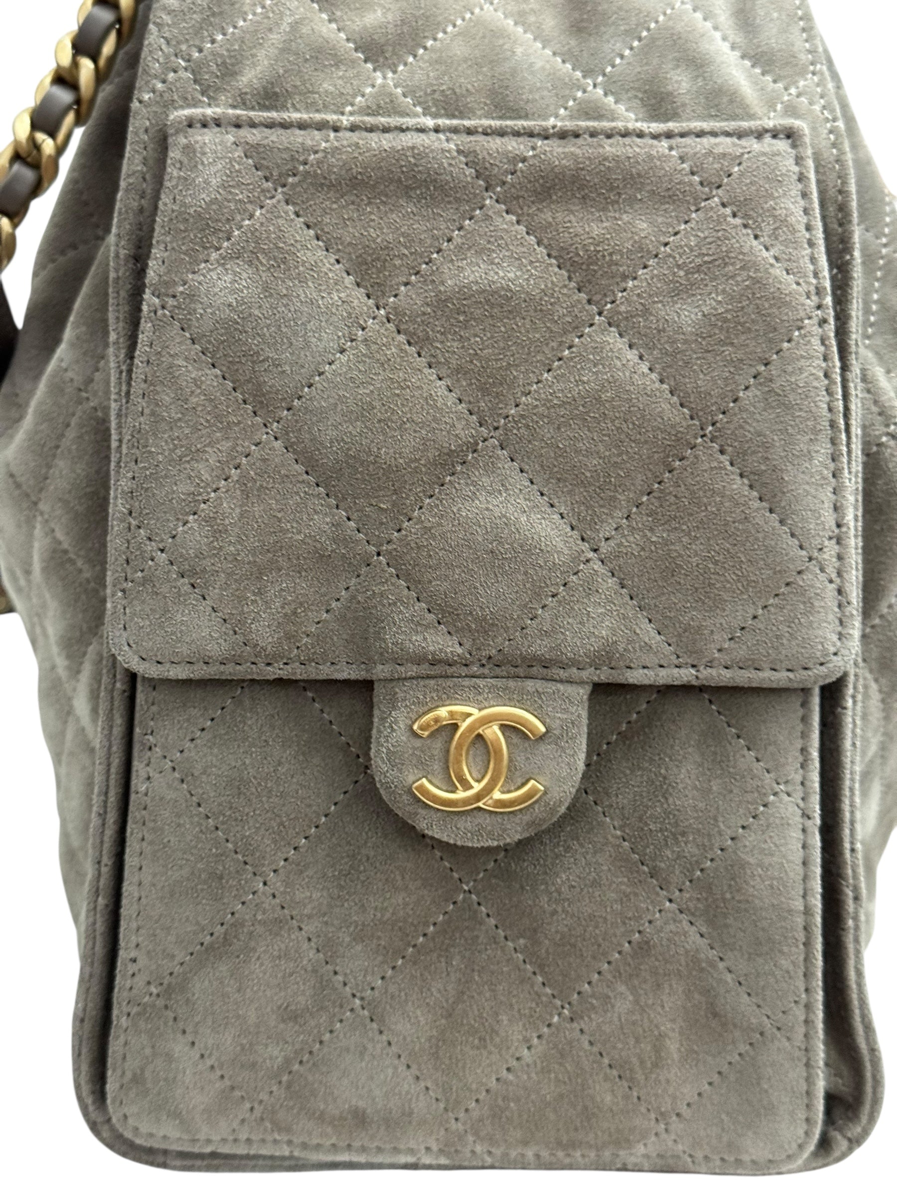 Gray quilted handbag with gold Chanel logo on a white background