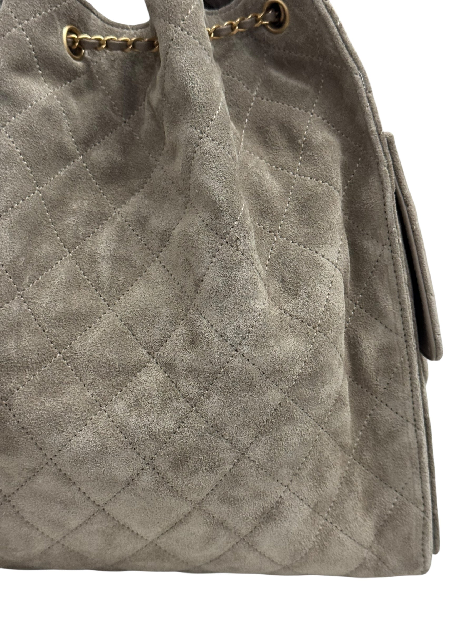 Gray quilted handbag with gold chain detail on a white background