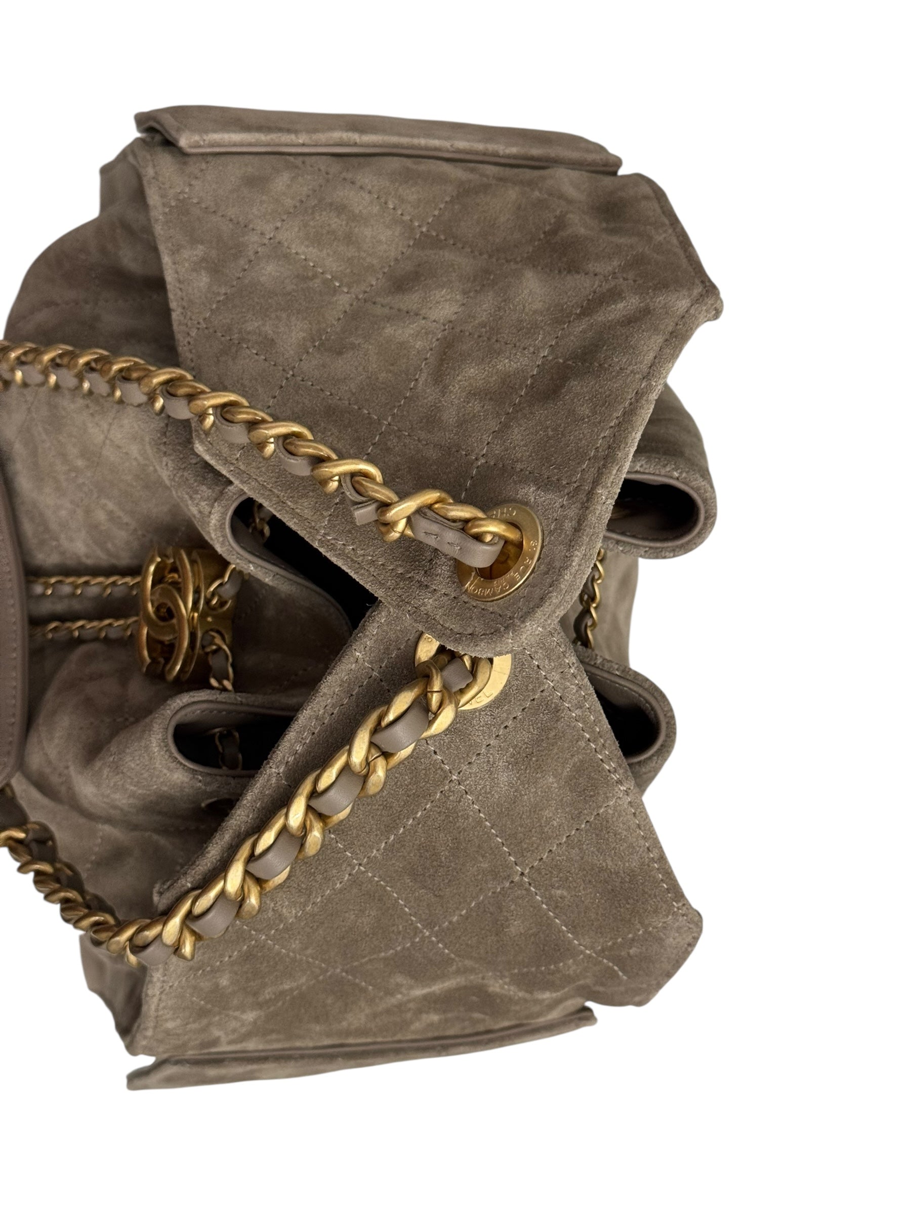 Brown quilted handbag with gold chain detail on a white background