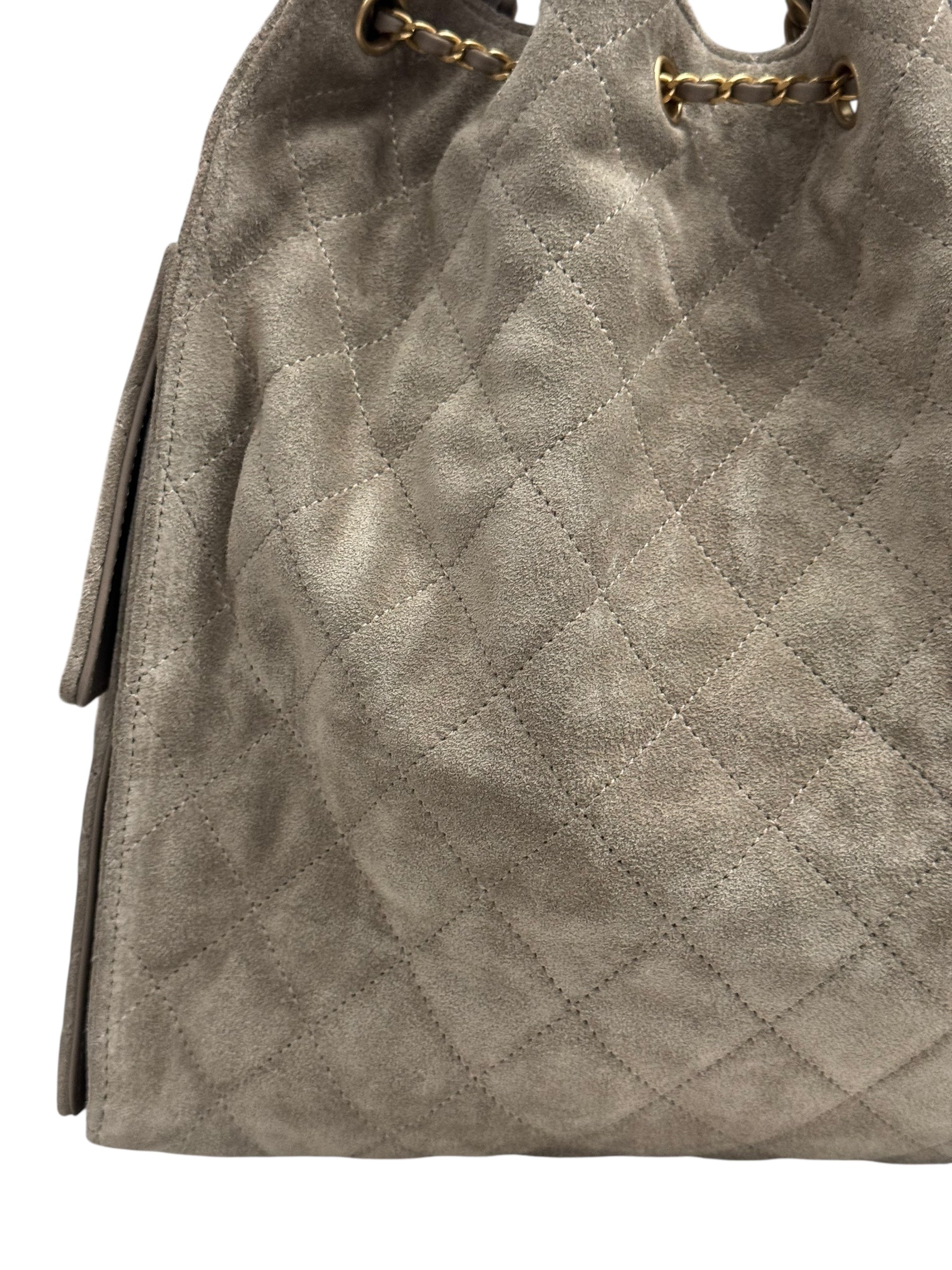 Quilted gray handbag with gold chain handle on a white background