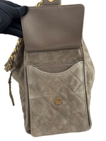 将图片加载到图库查看器，Gray quilted handbag with gold accents held by a gloved hand on a white background
