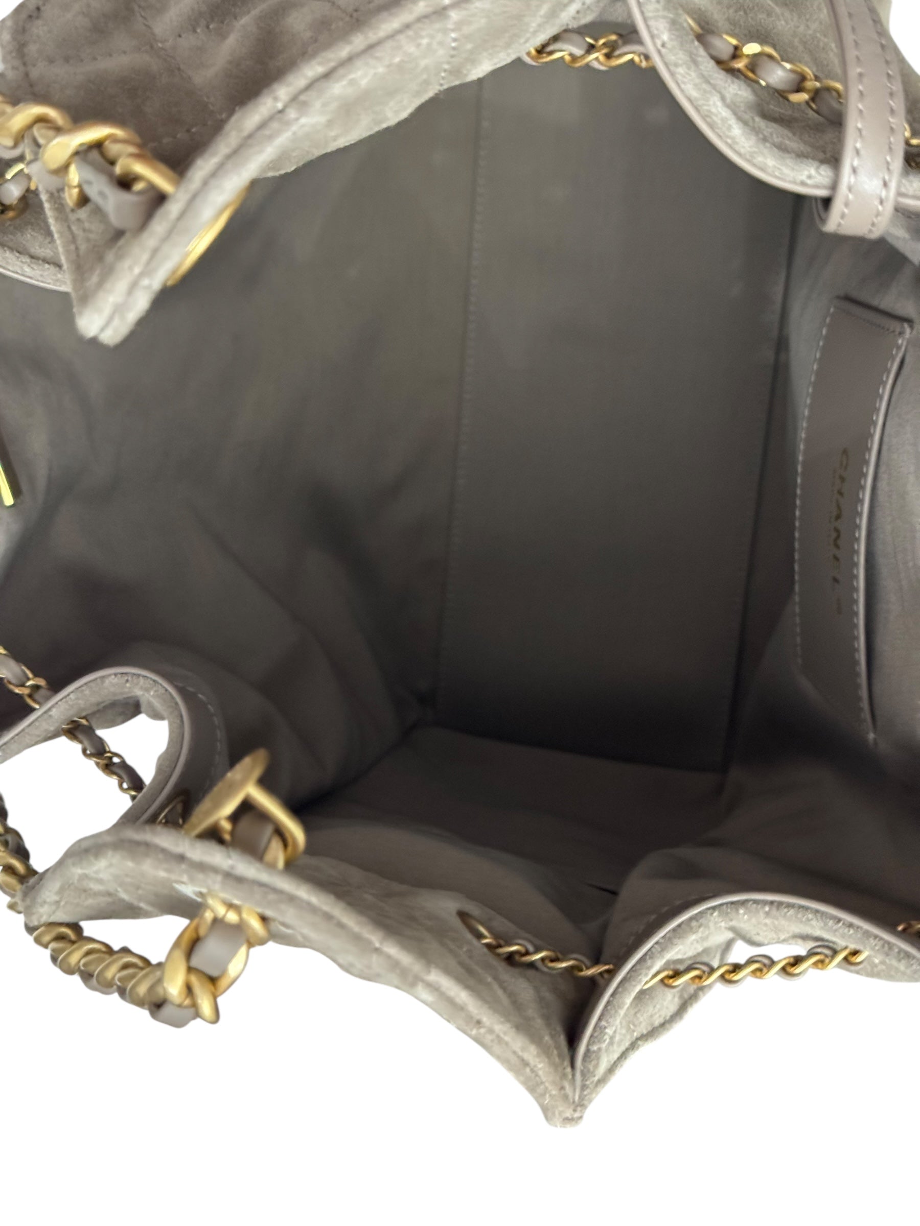 Close-up of a gray handbag with gold accents on a white background