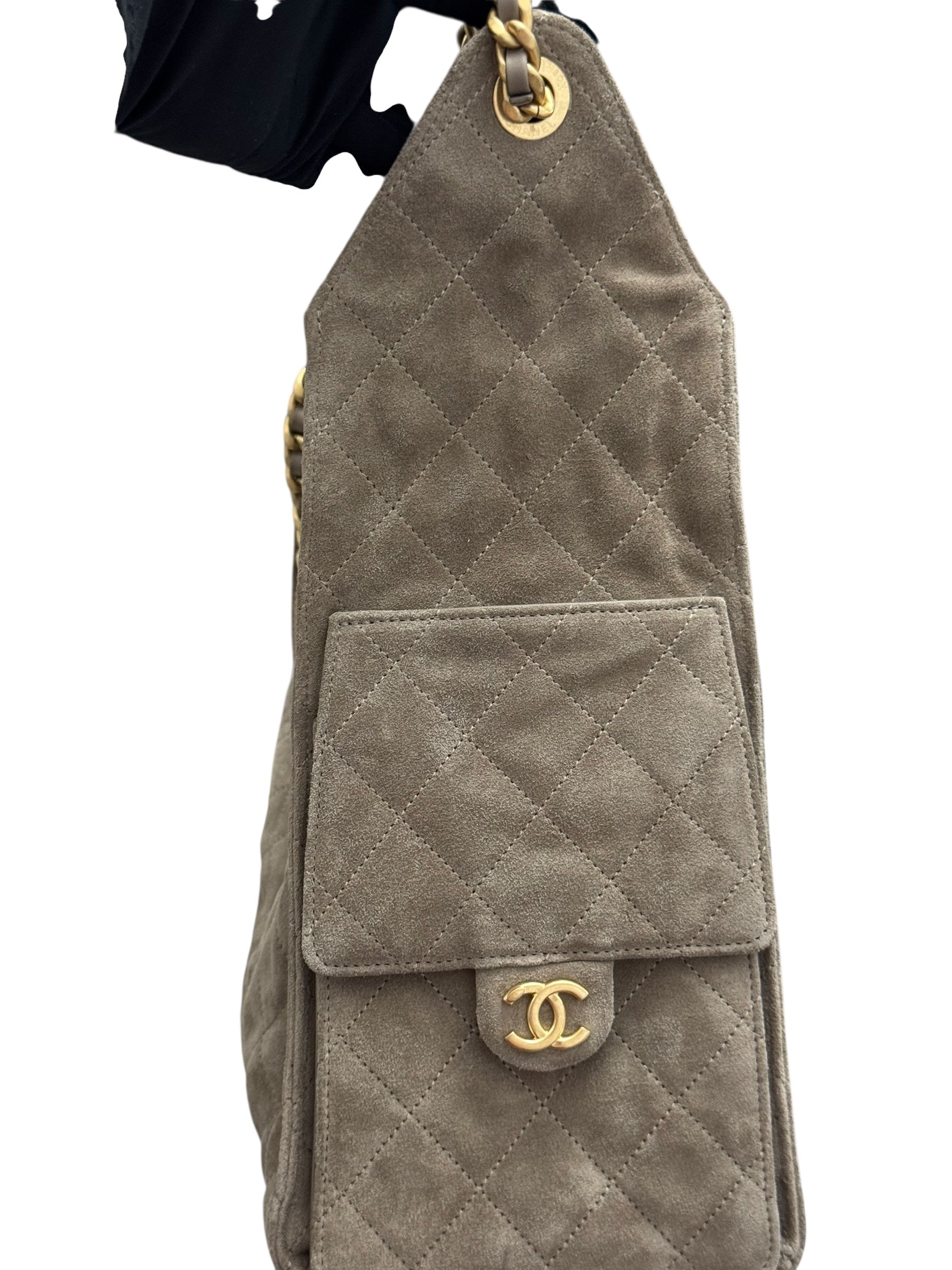 Quilted beige handbag with gold hardware on a white background