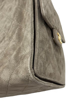 将图片加载到图库查看器，Close-up of a textured beige handbag with a gold clasp on a white background
