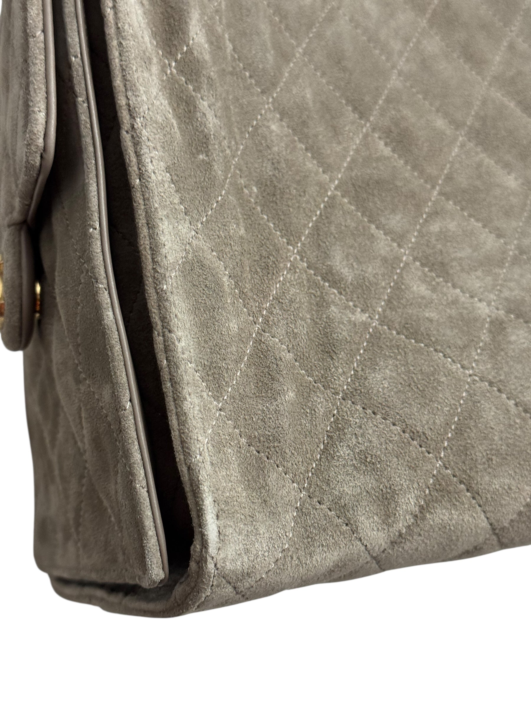 Close-up of a gray quilted handbag with a white background