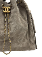 将图片加载到图库查看器，Gray suede handbag with gold chain and CC logo on a white background
