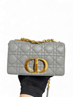 Load image into Gallery viewer, Gray quilted handbag with gold chain and clasp held by a hand against a white background
