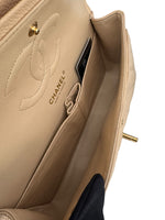 Load image into Gallery viewer, Close-up of a beige Chanel handbag with gold hardware on a white background
