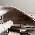 将图片加载到图库查看器，Close-up of a beige handbag with a metallic clasp on a neutral background
