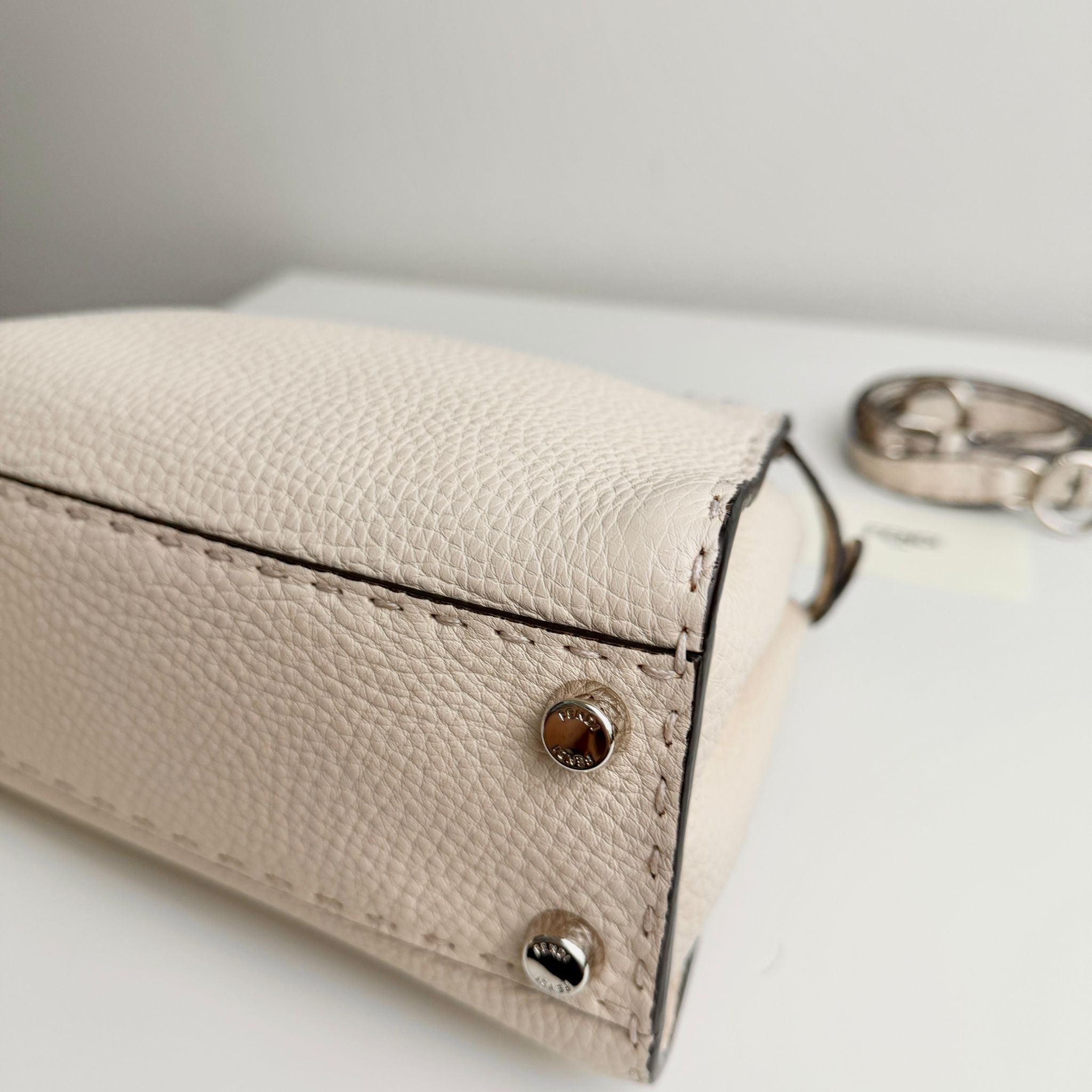 Beige leather case with gold accents on a white surface