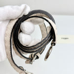 将图片加载到图库查看器，Close-up of a beige leather handbag with black strap held by a gloved hand on a light background.
