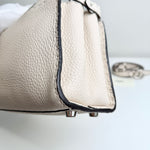 将图片加载到图库查看器，Close-up of a beige handbag with a keychain on a light background
