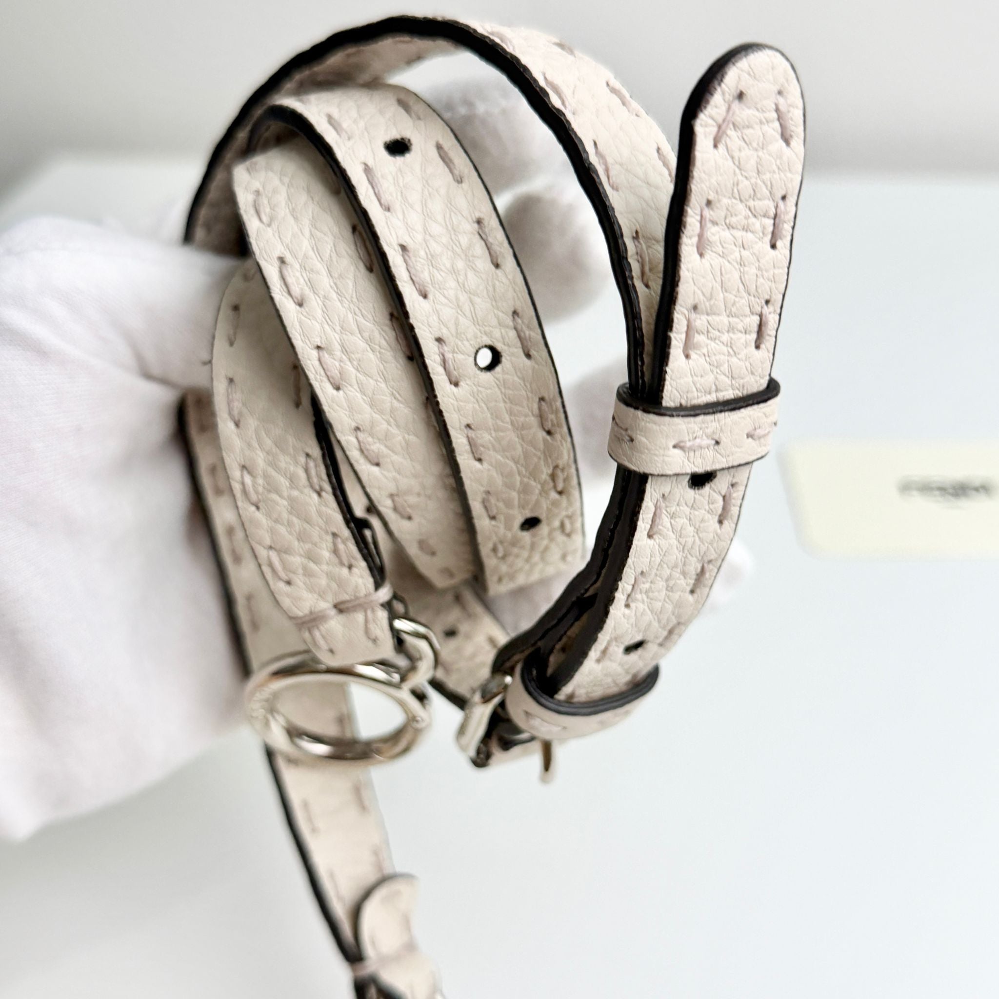 Two beige leather dog collars on a white background