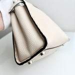 将图片加载到图库查看器，Close-up of a beige leather handbag with a black trim on a light background
