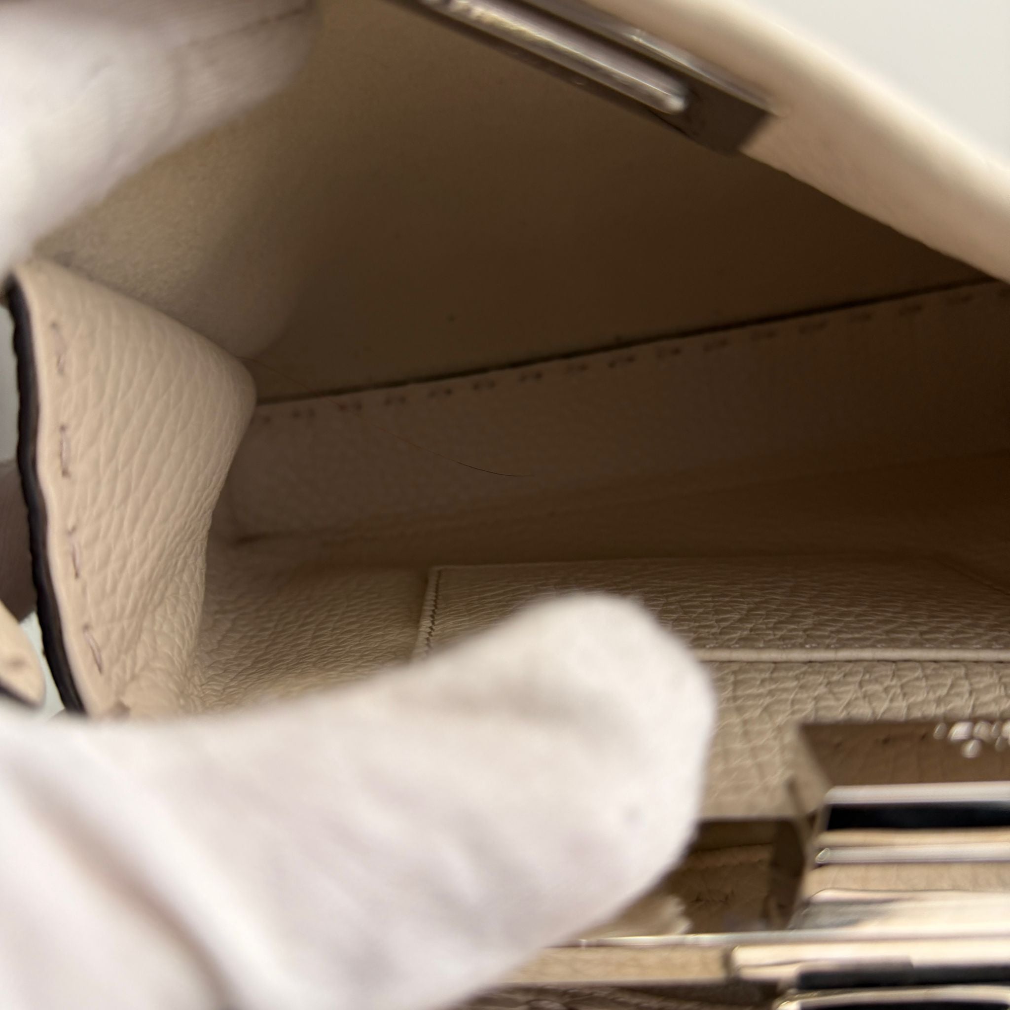 Close-up of a car door panel with leather texture and metallic handle.