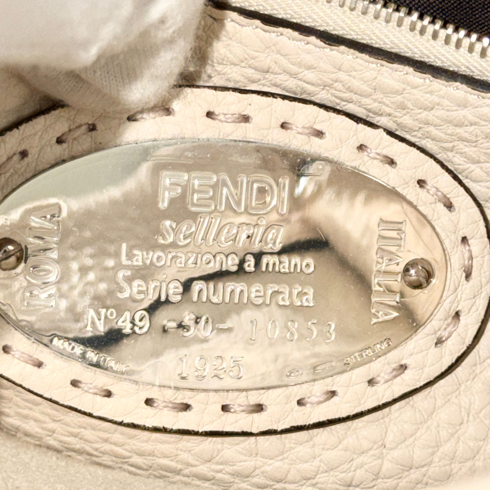 Fendi label on a beige leather product with 'FENDI' and 'ROMA' branding.