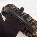 将图片加载到图库查看器，Black glove holding a black leather strap with a leopard print bag in the background
