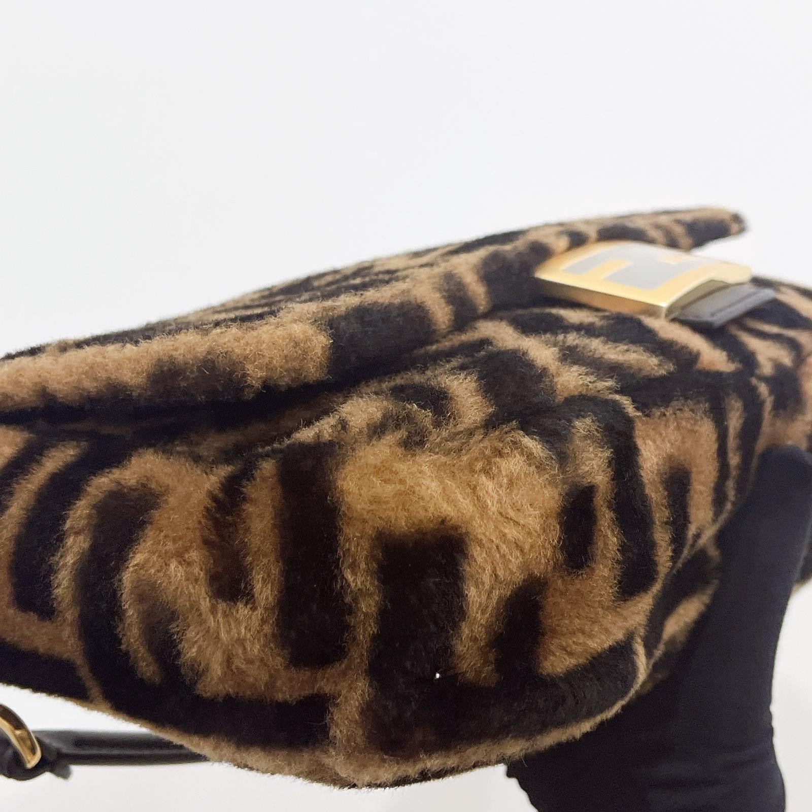 Leopard print handbag with a gold clasp on a white background