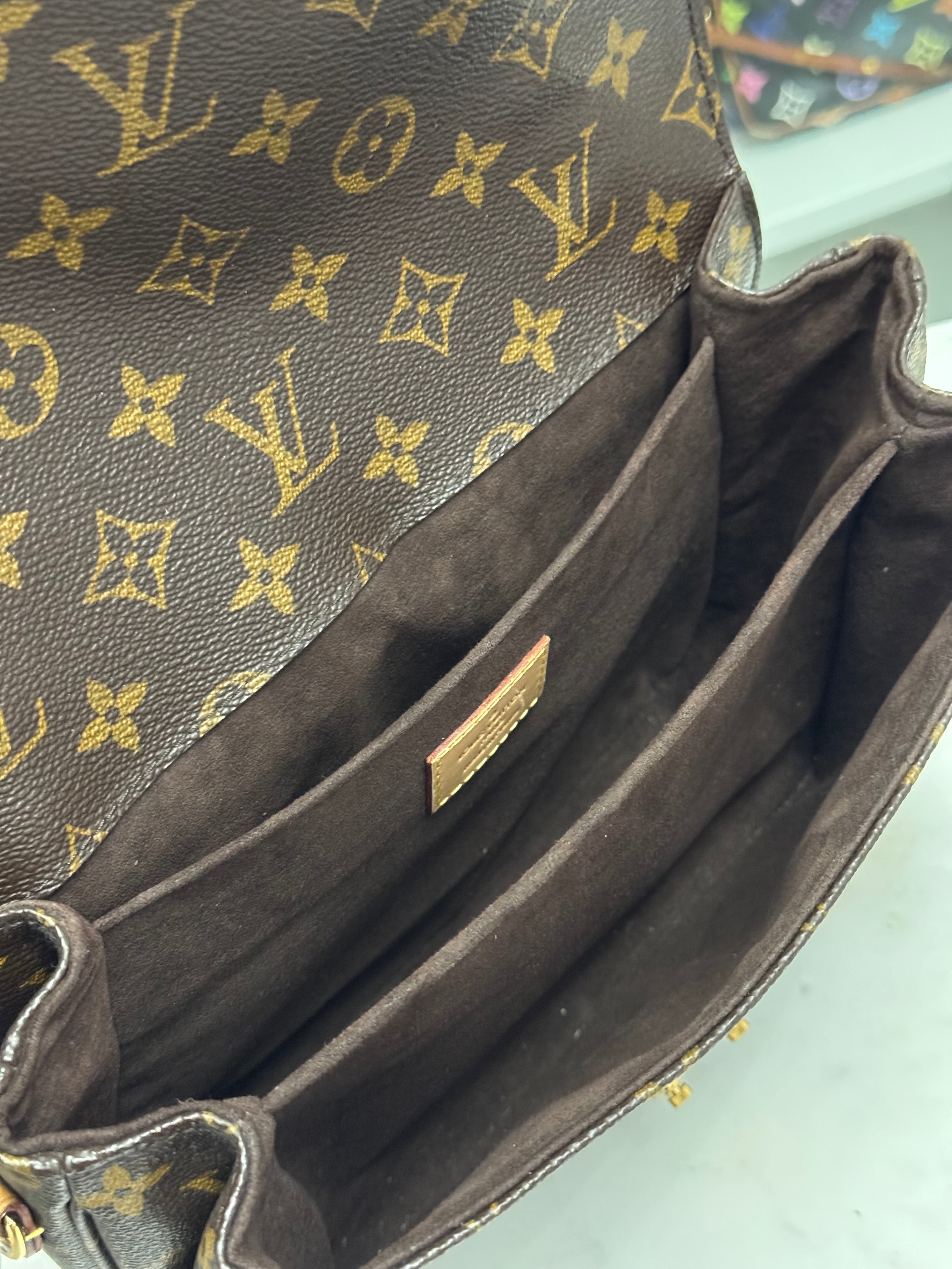 Close-up of a brown leather handbag with gold monogram pattern, brand logo visible.