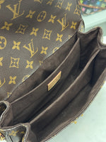 Load image into Gallery viewer, Close-up of a brown leather handbag with gold monogram pattern, brand logo visible.
