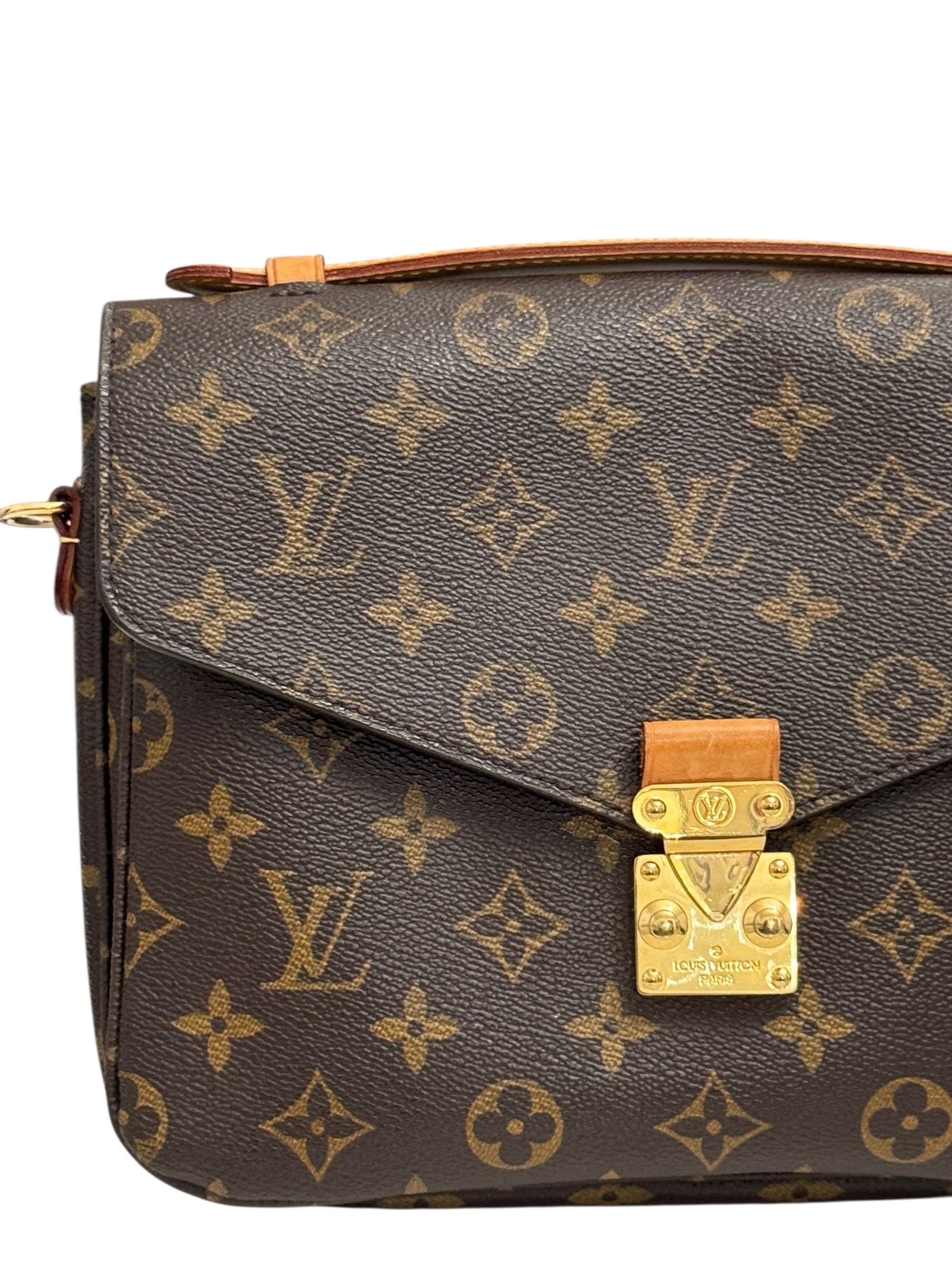 Designer handbag with monogram pattern and gold lock on a white background