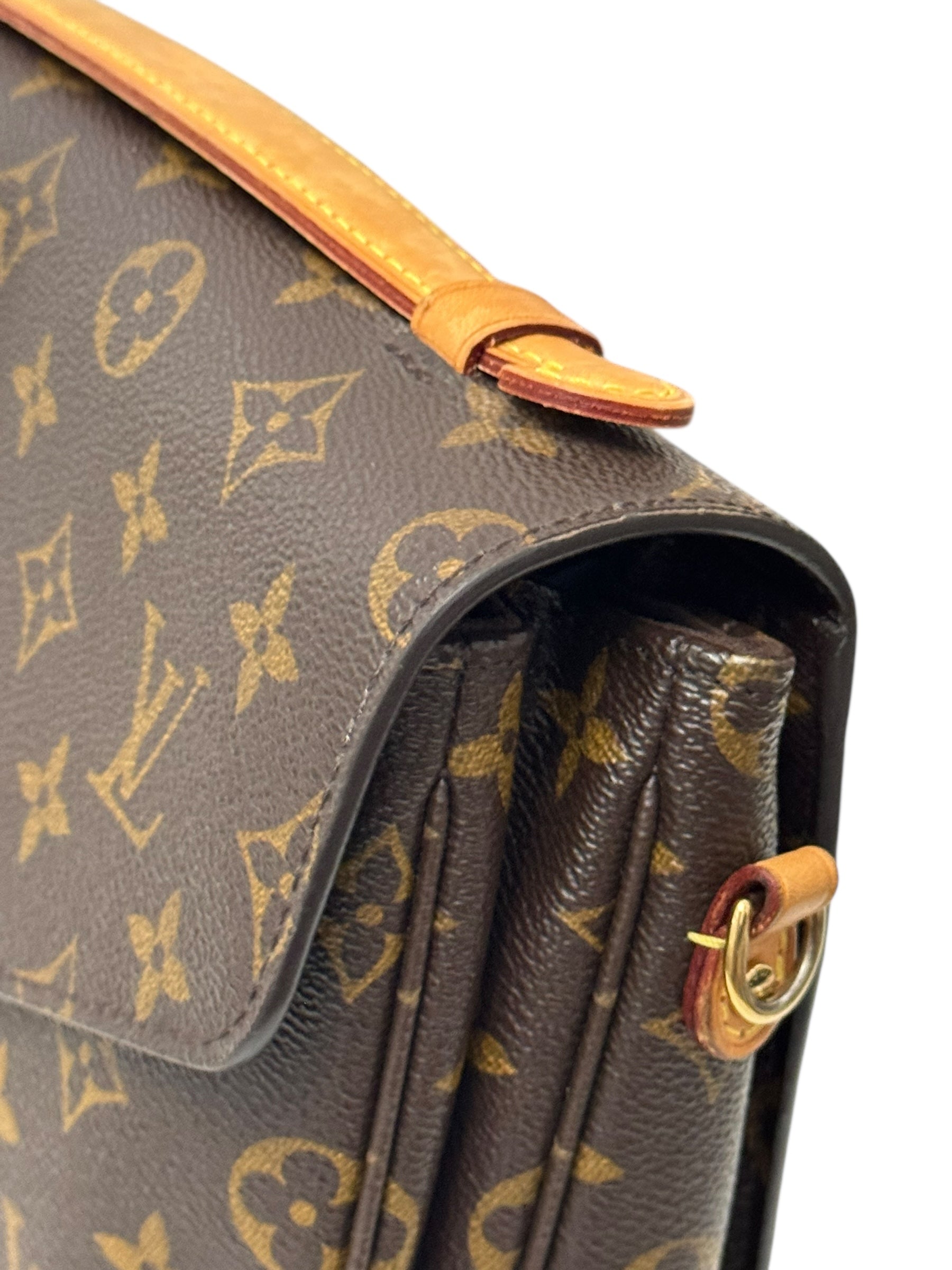 Close-up of a brown handbag with gold monogram pattern
