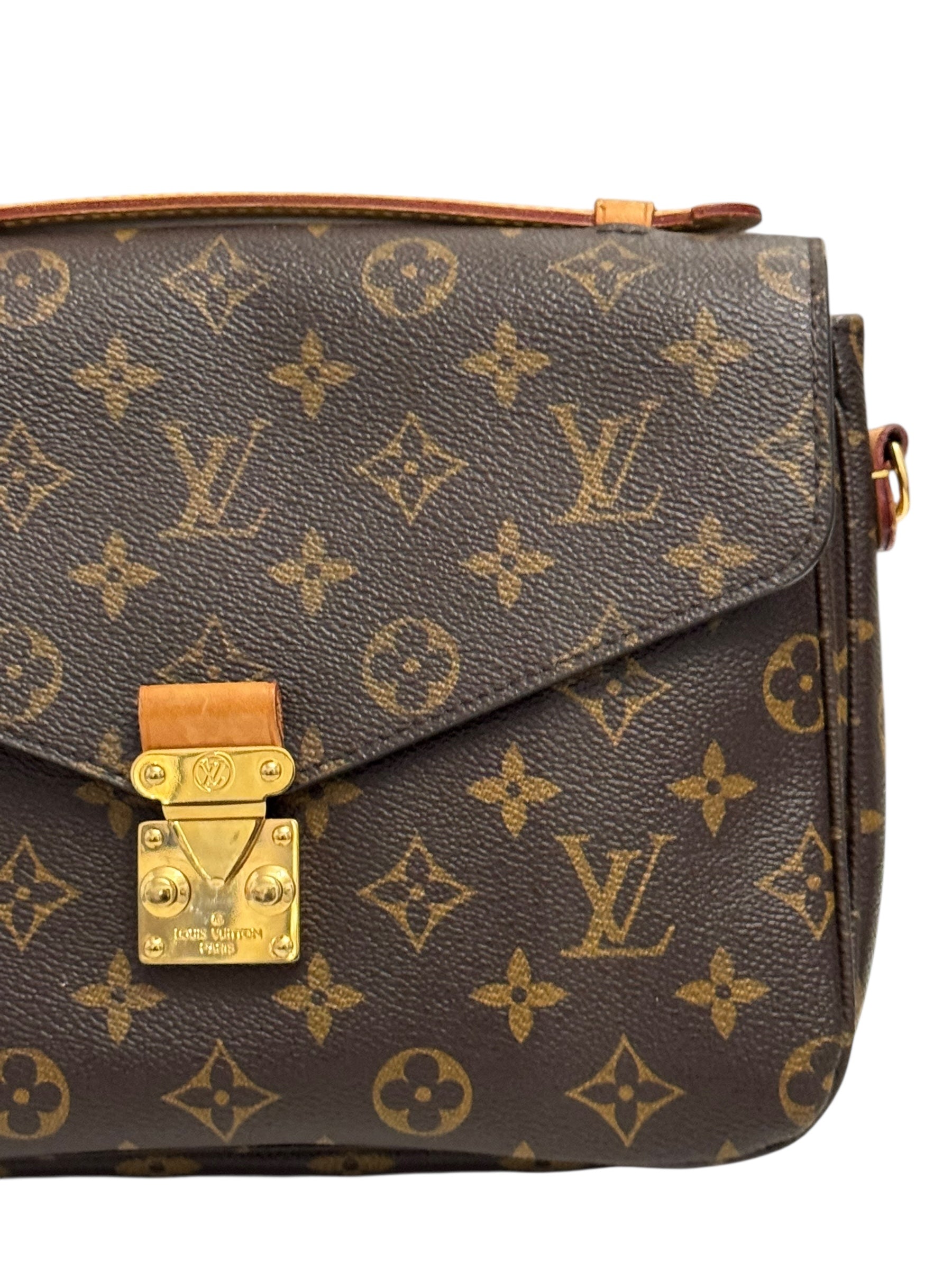 Brown handbag with gold lock and monogram pattern on a white background