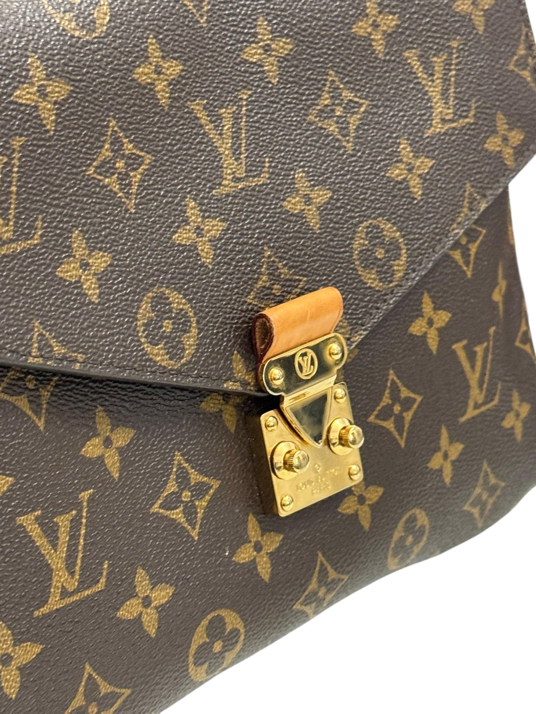 Close-up of a Louis Vuitton handbag with monogram pattern and gold lock.