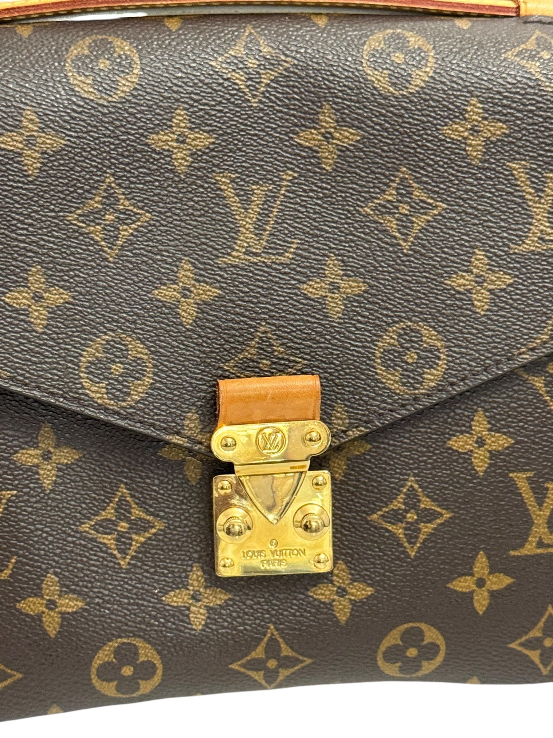 Close-up of a Louis Vuitton handbag with monogram pattern and gold lock.
