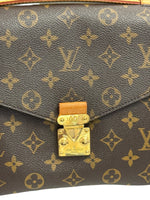 Load image into Gallery viewer, Close-up of a Louis Vuitton handbag with monogram pattern and gold lock.
