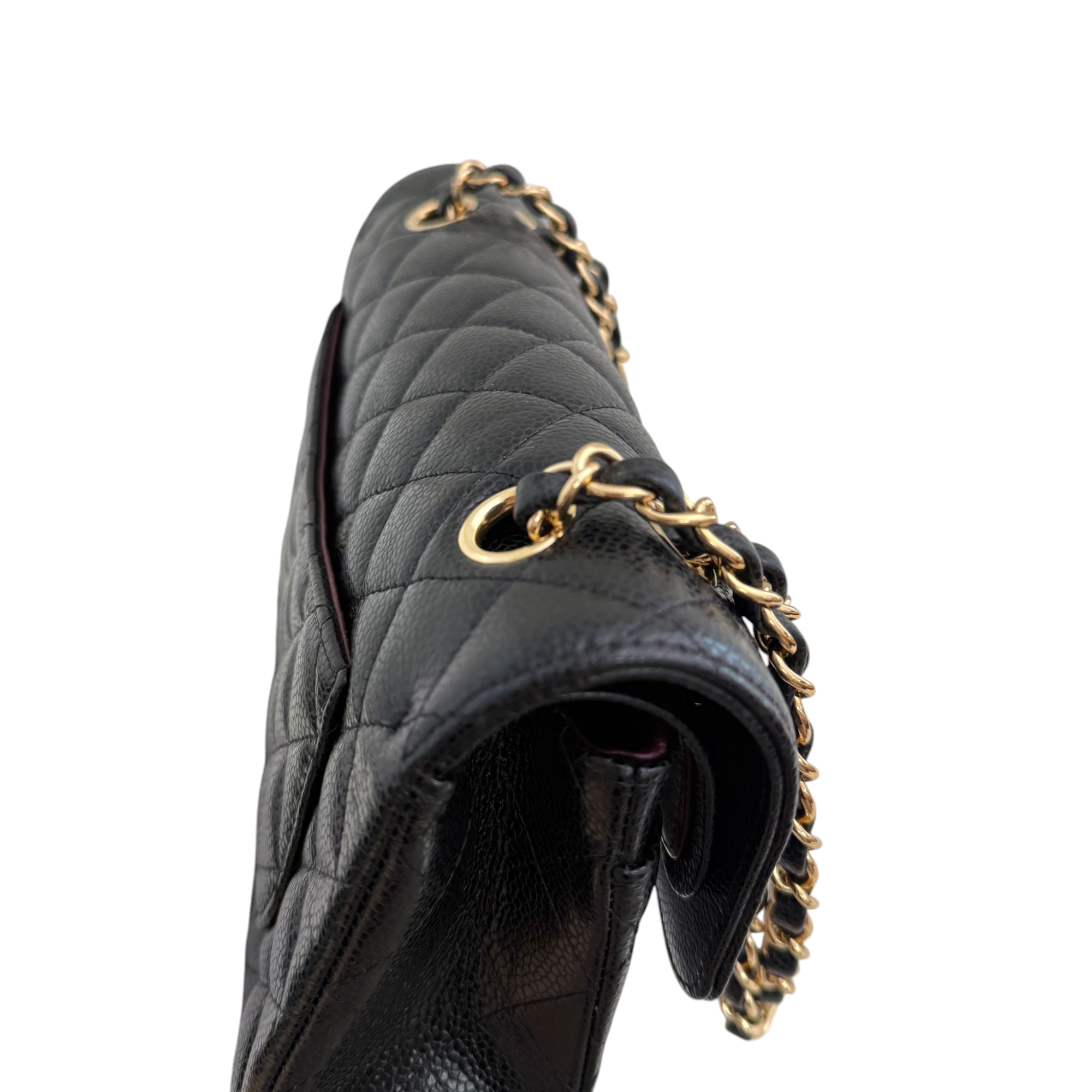 Black quilted handbag with gold chain strap on a white background