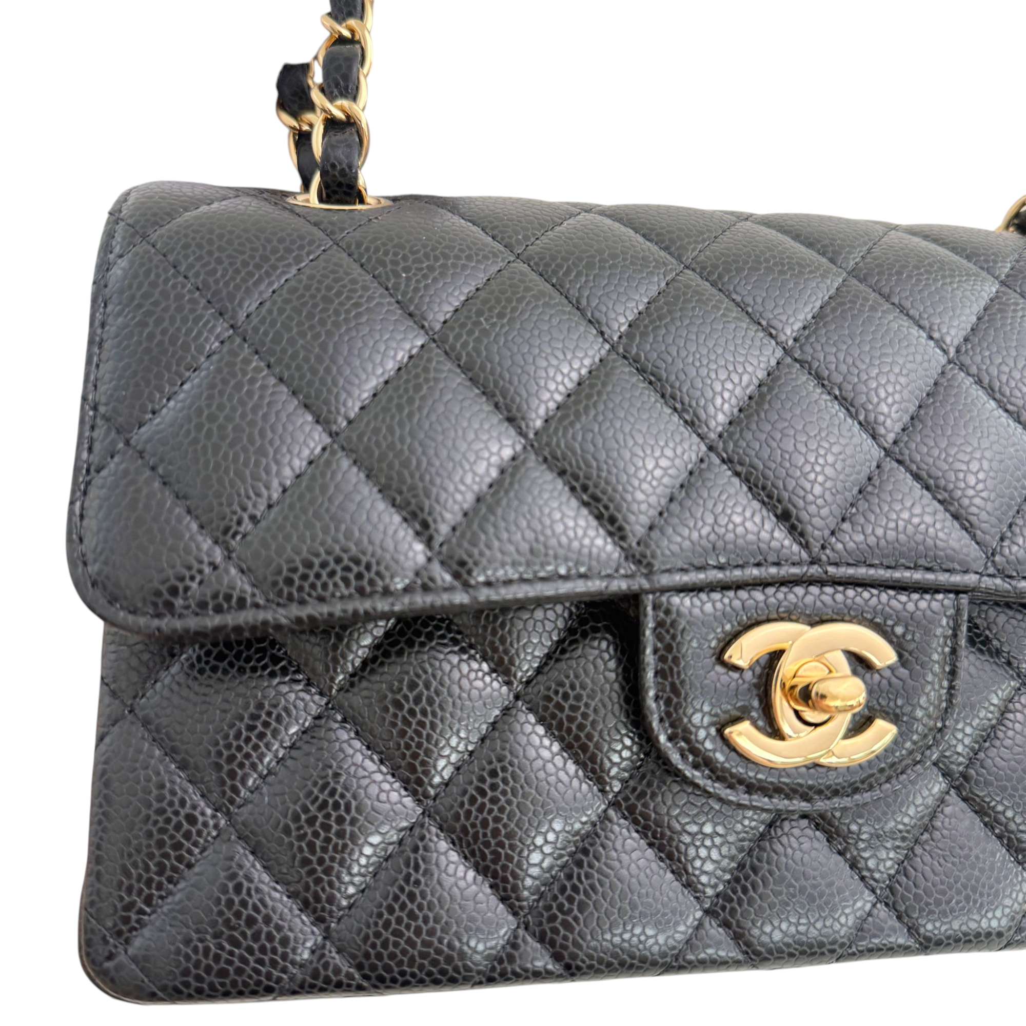 Quilted gray handbag with gold Chanel logo on a white background