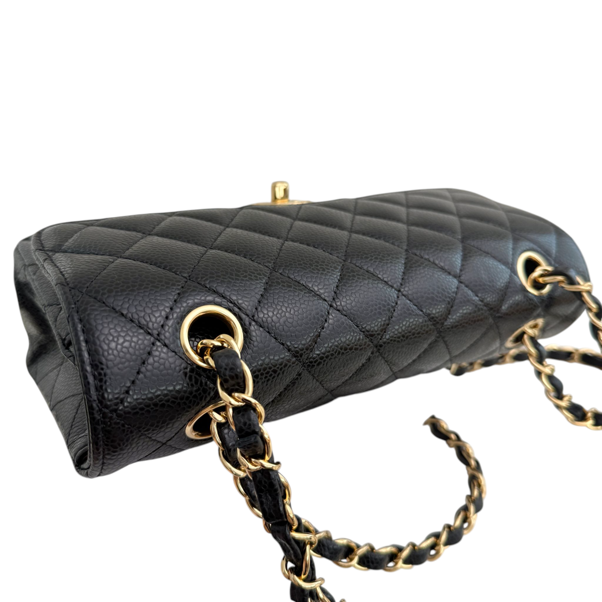 Black quilted handbag with gold chain strap on a white background