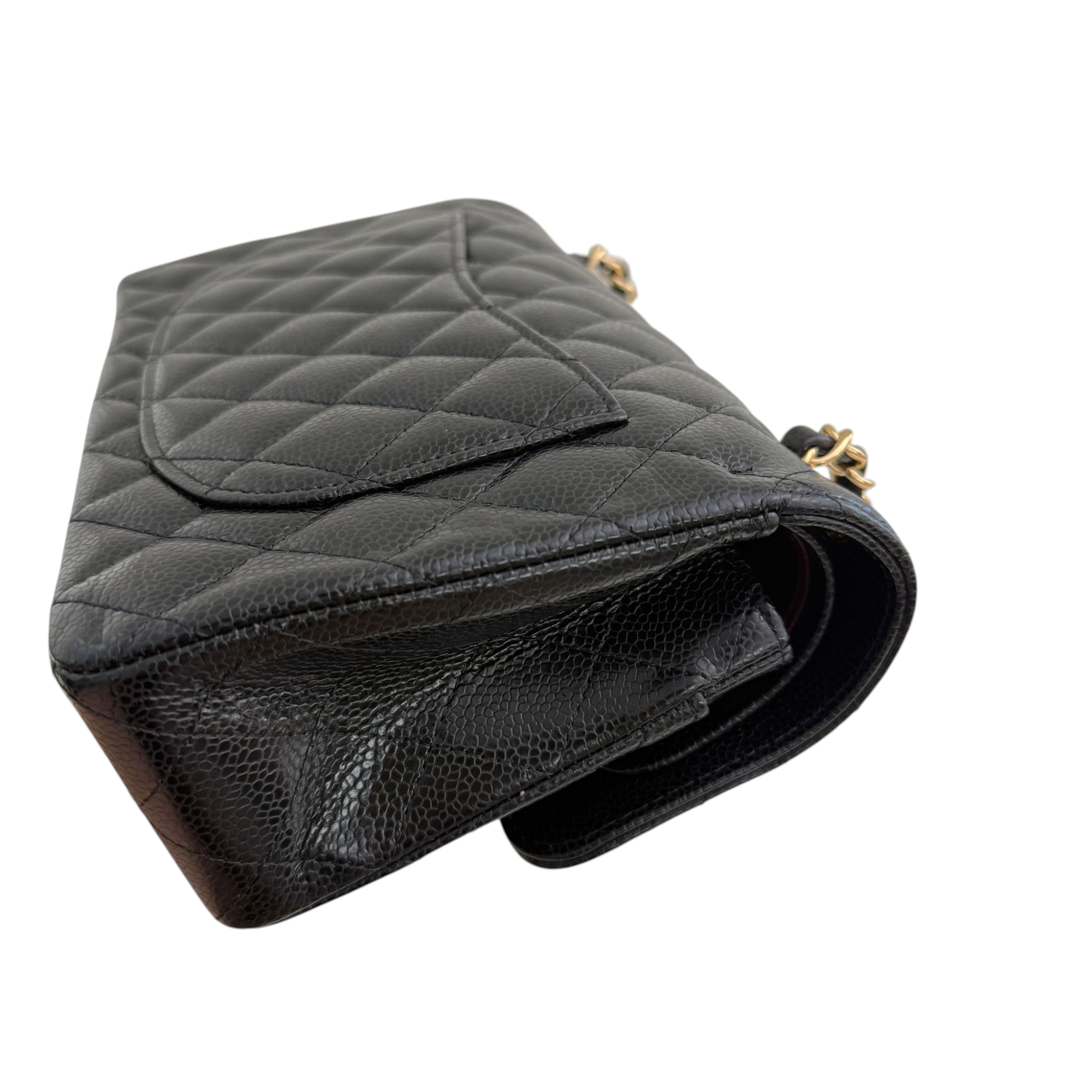Black quilted handbag with gold hardware on a white background