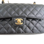 Charger l&#39;image dans la galerie, Black quilted handbag with gold clasp on a white background
