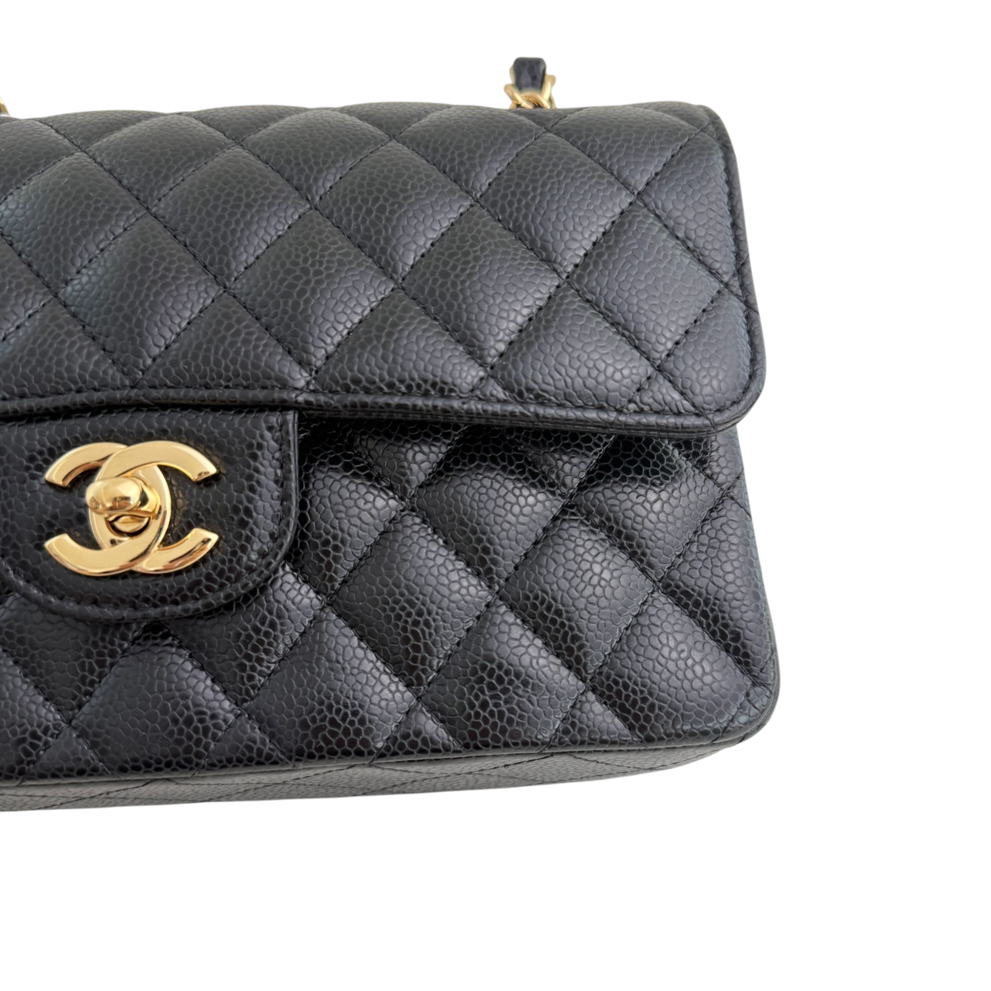 Black quilted handbag with gold Chanel logo on a white background
